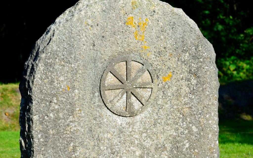 The symbol of the Wheel of the Year appears on an old stone.